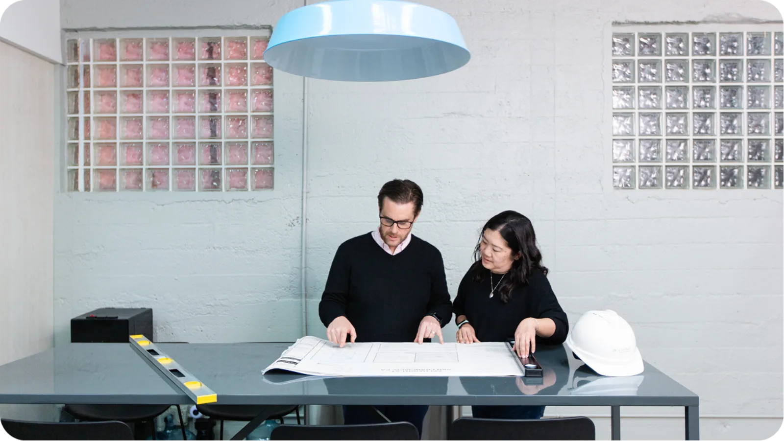 Brooks Baskin and a 2B Living colleague reviewing plans